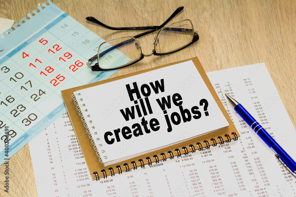 HOW WILL WE CREATE JOBS'. blank notebook with markers pen beside. The notebook is on paper with text . Colored pencils and eyeglasses. Concept photo for BUSINESS, FINANCE, MARKETING HOW WILL WE CREATE JOBS'. blank notebook with markers pen beside. The notebook is on paper with text . Colored pencils and eyeglasses. Concept photo for BUSINESS, FINANCE, MARKETING