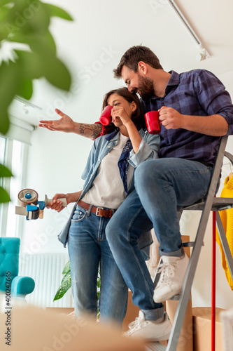 Couple drinking coffee and planing apartment redecoration while moving in together