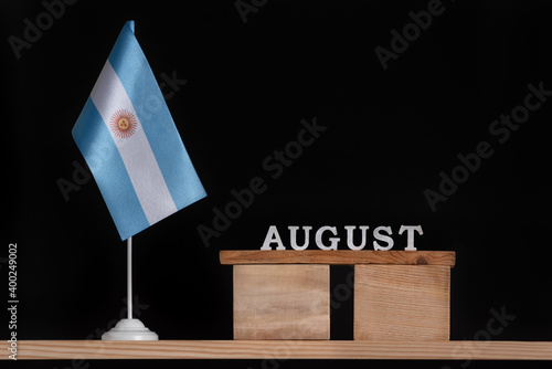 Wooden calendar of August with Argentine flag on black background. Dates of Argentina in August