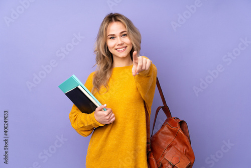 Teenager Russian student girl isolated on purple background making phone gesture and pointing front