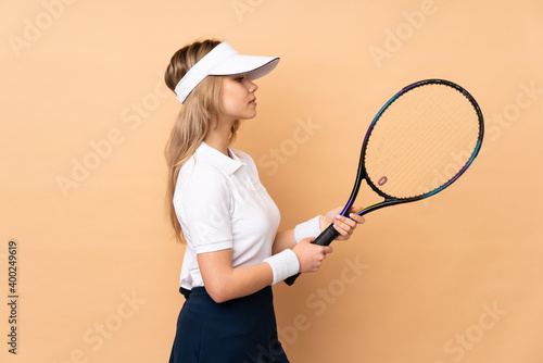 Teenager Russian girl isolated on beige background playing tennis