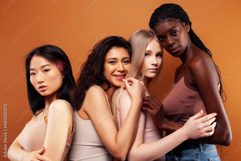 Obraz premium young pretty asian, caucasian, afro woman posing cheerful together on brown background, lifestyle diverse nationality people concept