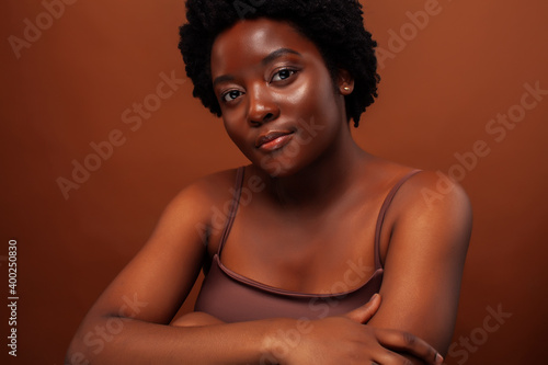 young pretty african model smiling happy on brown backround, lifestyle people concept