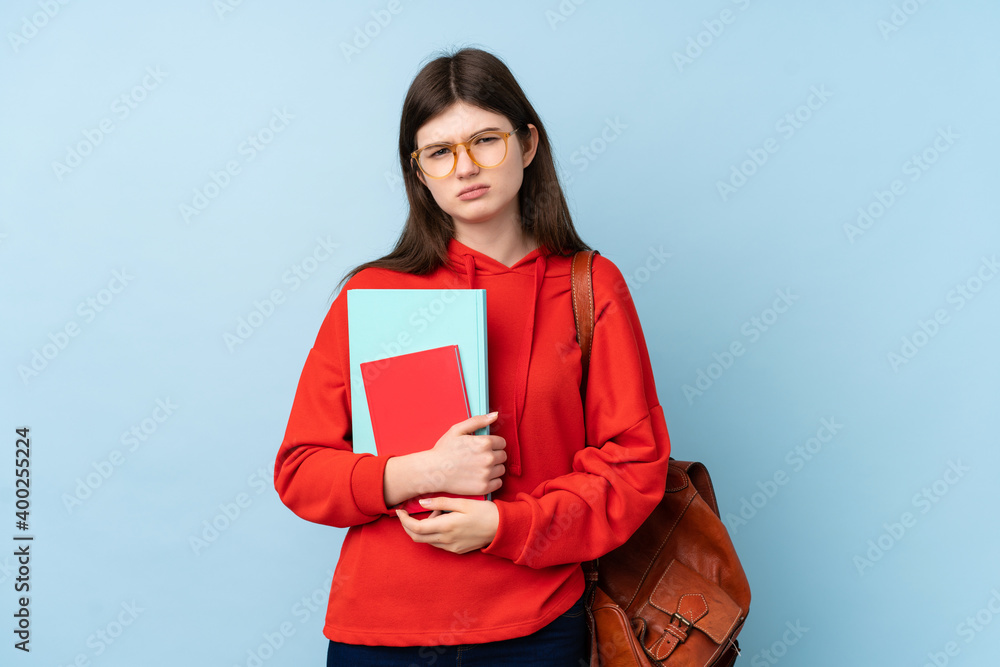Obraz premium Young Ukrainian teenager student girl holding a salad over isolated blue background sad