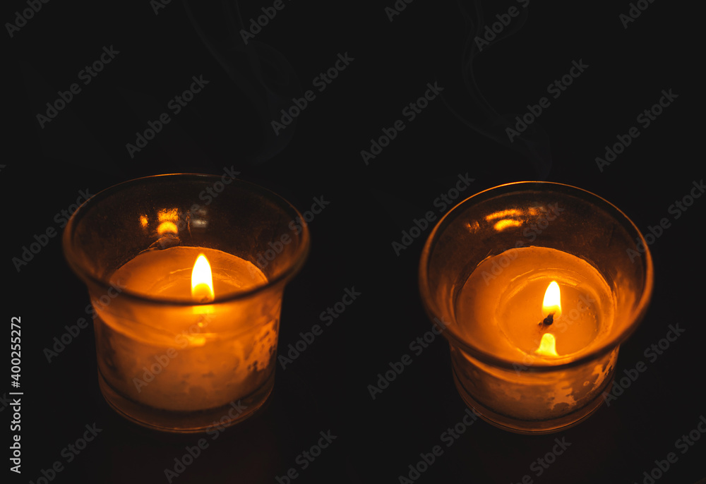 Collage with two candles in a glass, detailed photo of home lighting, comfort and mood, copy space, black background Collage with two candles in a glass, detailed photo of home lighting, comfort and mood, copy space, black background
