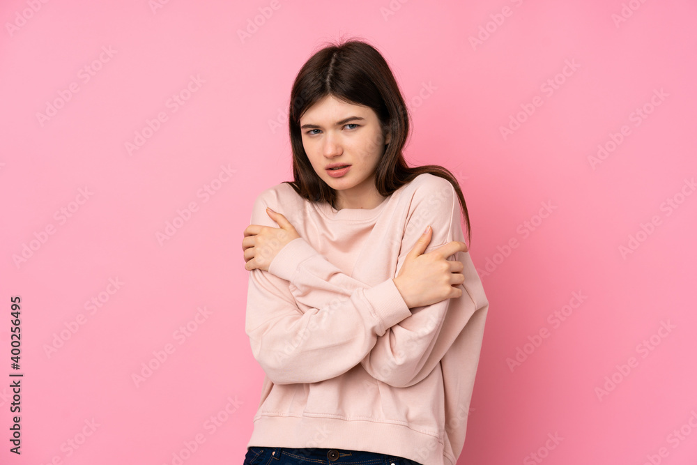 Young Ukrainian teenager girl over isolated pink background freezing