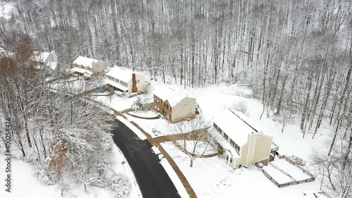 A daytime aerial winter establishing shot of a typical upscale Pennsylvania residential neighborhood. Cars pass below. Pittsburgh suburbs.  	