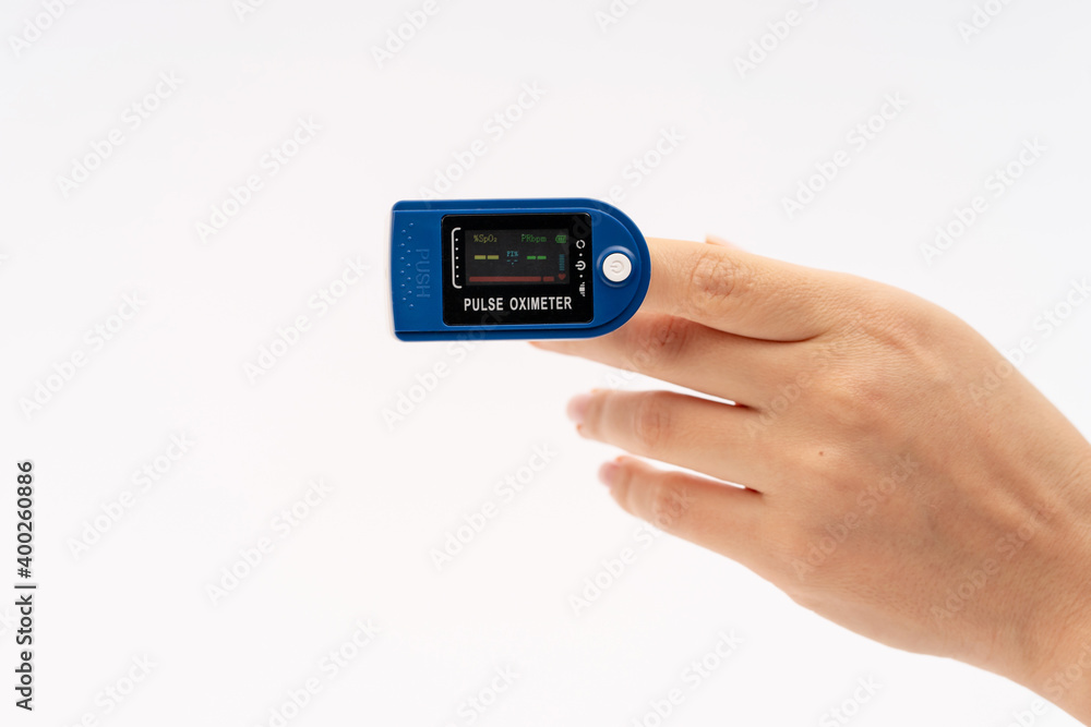 Fingertip Pulse Oximeter on finger. On white background. Device for self health diagnostic Fingertip Pulse Oximeter on finger. On white background. Device for self health diagnostic