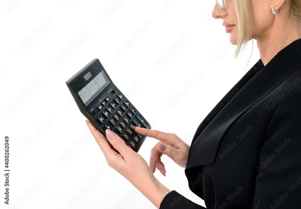 Female accountant in a black suit clicks on a calculator to calculate tax financial expenses Female accountant in a black suit clicks on a calculator to calculate tax financial expenses
