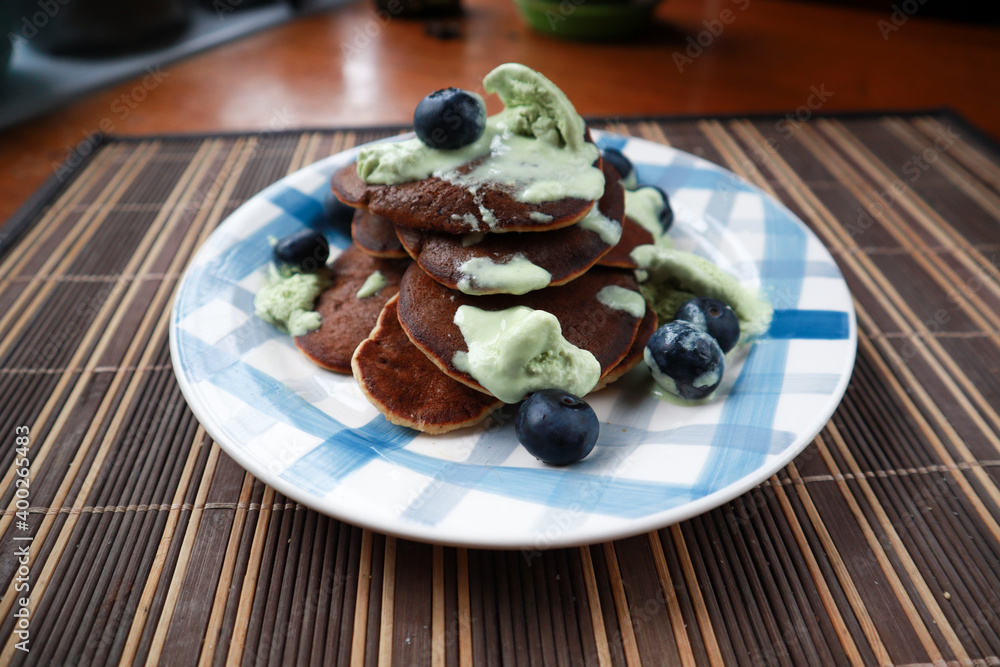 Homemade pancakes with blueberries and ice cream. Plate with blue paint strokes Homemade pancakes with blueberries and ice cream. Plate with blue paint strokes