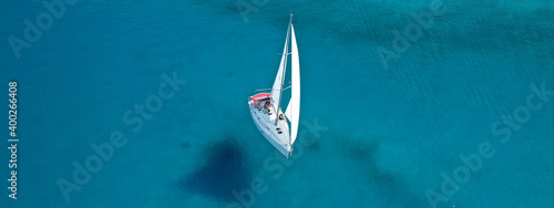 Aerial drone ultra wide photo of beautiful sail boat cruising tropical exotic bay with turquoise sea
