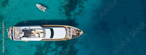 Aerial drone ultra wide top down photo of luxury yacht anchored in tropical exotic bay with emerald crystal clear sea