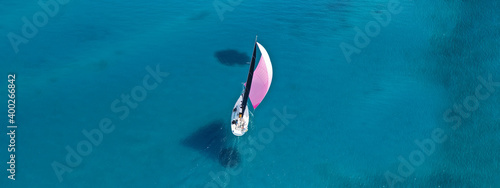 Aerial drone ultra wide photo of beautiful sail boat cruising tropical exotic bay with turquoise sea