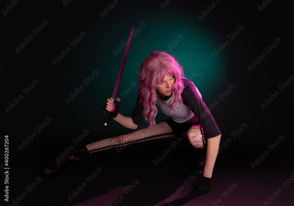 Fototapeta premium Punk rock sexy female assassin with pink hair wearing black, holding a weapon.