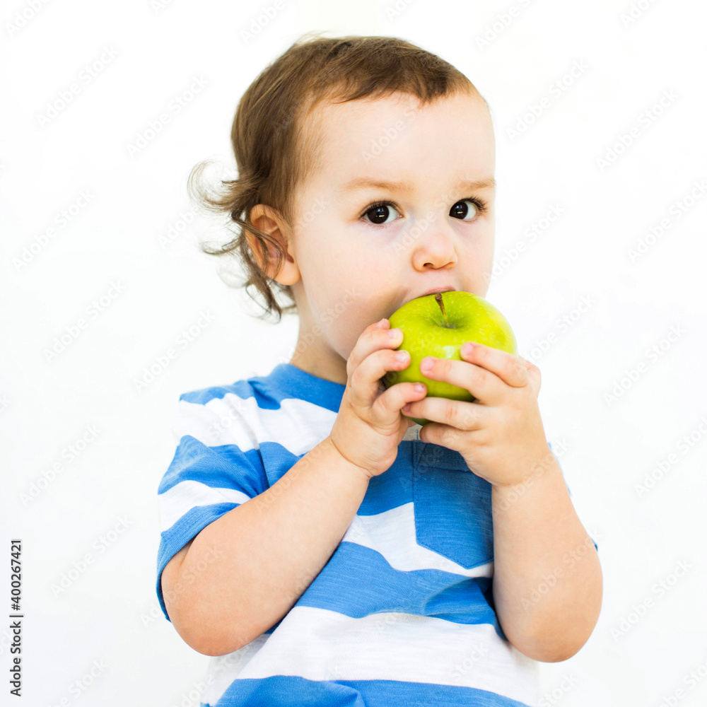 Boy (4-5) wearing t-shirt eating green apple Boy (4-5) wearing t-shirt eating green apple