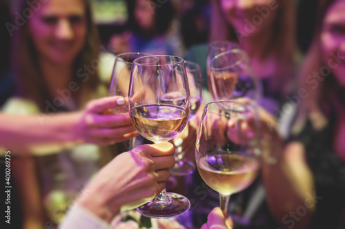 People celebrate and raise glasses, cheering with alcohol glasses with wine and champagne in the restaurant on corporate christmas birthday party event or wedding celebration