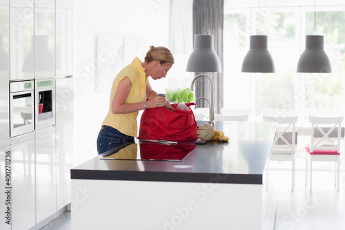 Woman unpacking groceries from shopping bag photo