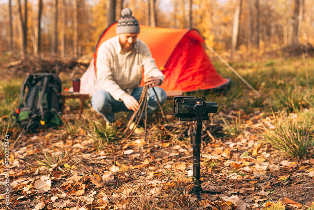 Camera shooting traveler making fire in forest Camera shooting traveler making fire in forest