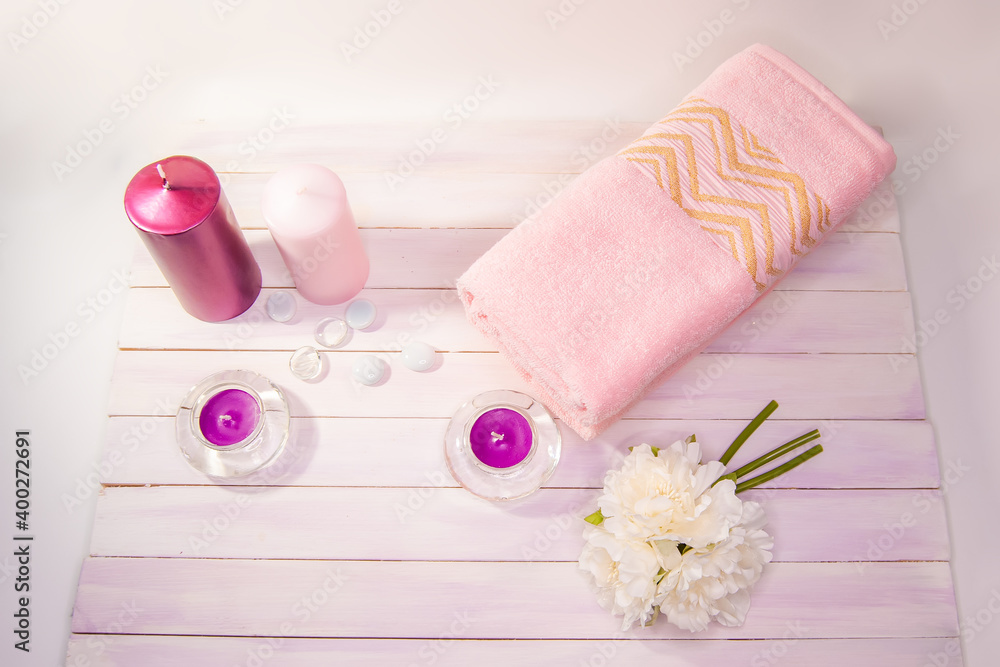 Spa still life - a flowers and towels on a wooden background. Beige, pink and white tones. The view from the top. Spa still life - a flowers and towels on a wooden background. Beige, pink and white tones. The view from the top.