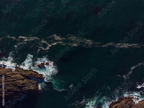 View from above of the ocean waves and fantastic rocky coast. Wallpaper design. Amazing landscape.