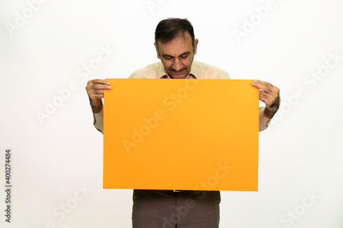 Man holding billboard in his hand. The man is dressed in a white shirt and fabric pants. Isolated image on white background.
