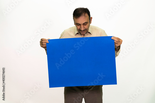 Man holding billboard in his hand. The man is dressed in a white shirt and fabric pants. Isolated image on white background.