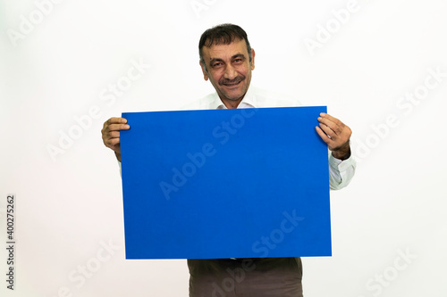 Man holding a blue banner in his hand. It can be written on. She is dressed in a white shirt and fabric pants. Isolated image white background.