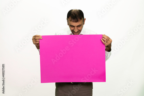 Man holding a purple banner in his hand. It can be written on. She is dressed in a white shirt and fabric pants. Isolated image white background.