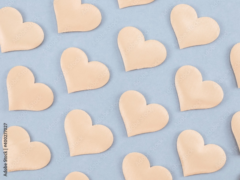 Obraz premium Background with hearts on gray.Background with hearts of champagne color arranged diagonally on gray, top view close-up.