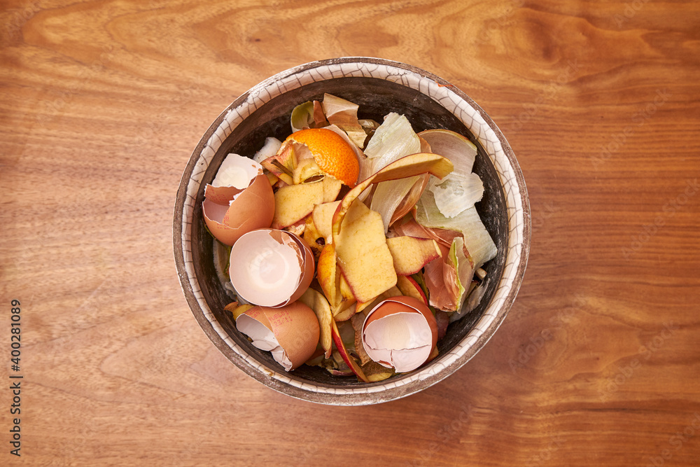 Domestic Peeled Apples, Eggs & Onions In A Ceramic Pot On A Raw Wooden Table Waiting To Be Composted Domestic Peeled Apples, Eggs & Onions In A Ceramic Pot On A Raw Wooden Table Waiting To Be Composted