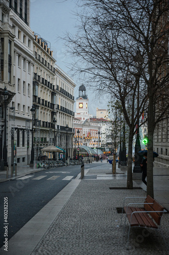Nice winter view of the Puerta del Sol tower from Alcala street with people walking while it gets dark and the streetlights are lit