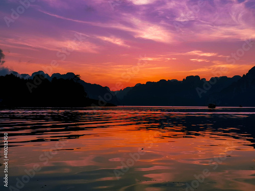 slightly different sun over a mountain on a lake in thailand  but it s purple and orange