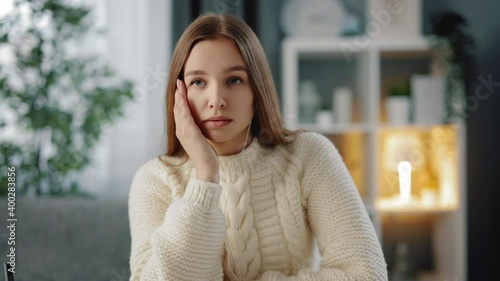 Cute young woman with brown hair feeling tired because of long studying at home. Exhausted student in casual outfit sigh heavily while sitting at table.