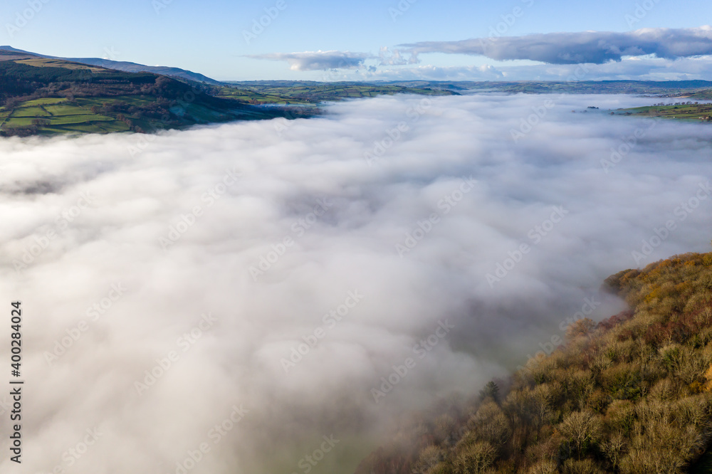 Aerial view of a beautiful rural valley filled with a blanket of thick fog