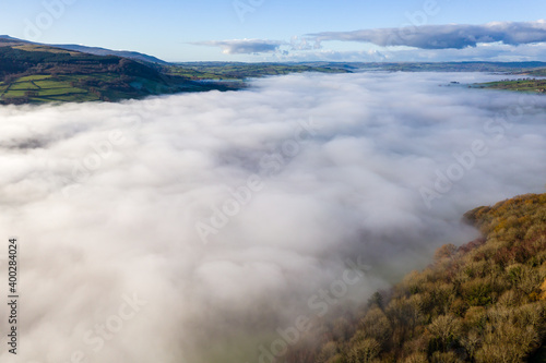 Aerial view of a beautiful rural valley filled with a blanket of thick fog