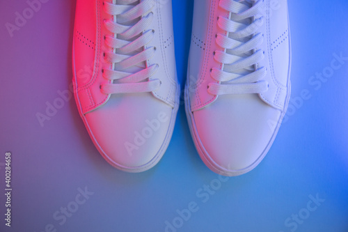 Pair of sneakers on color background, top view