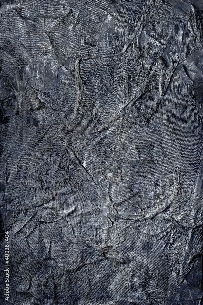 Textured handmade dark textile background with mesh and paper base. Vertical background handmade for design, in black-and-white color Textured handmade dark textile background with mesh and paper base. Vertical background handmade for design, in black-and-white color