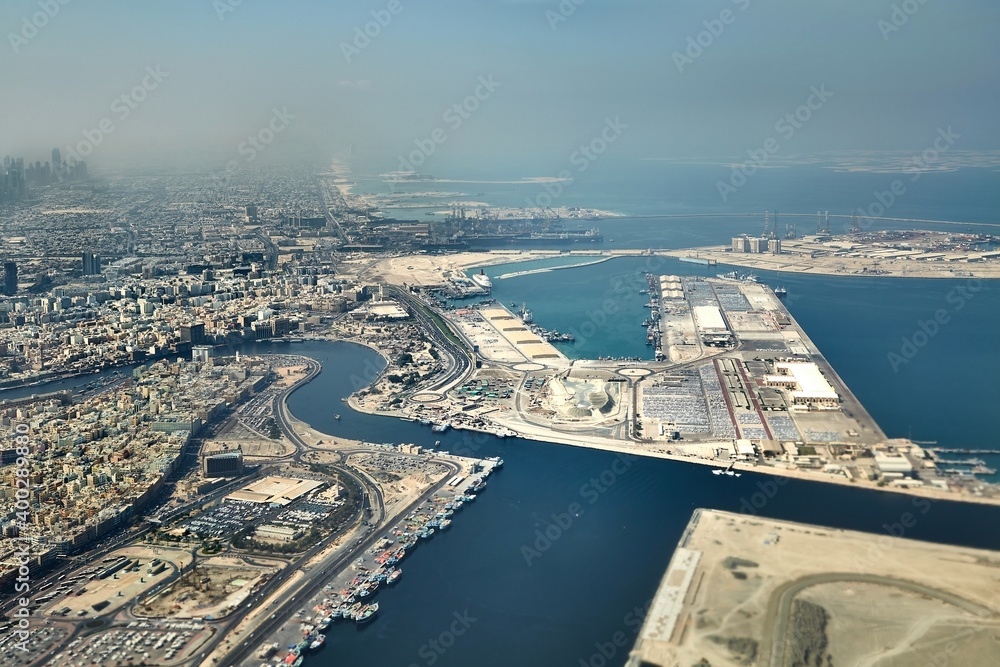 Fototapeta premium Dubai city view from air with industrial construction projects on artificial islands, land reclaimed from the sea