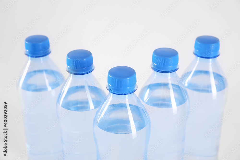 Naklejka premium Plastic bottles with pure water on white background, closeup