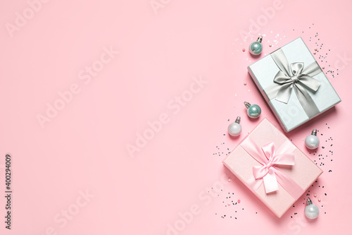 Beautiful gift boxes, Christmas balls and confetti on pink background, flat lay. Space for text © New Africa
