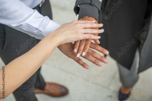 Business meeting. One man and two women stacking their hands © jovannig