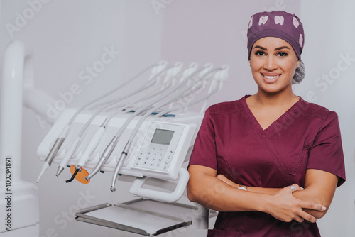 Young blond Caucasian female opening her mouth while African-American ethnic dentist in white latex gloves check condition of her teeth focus on dentist