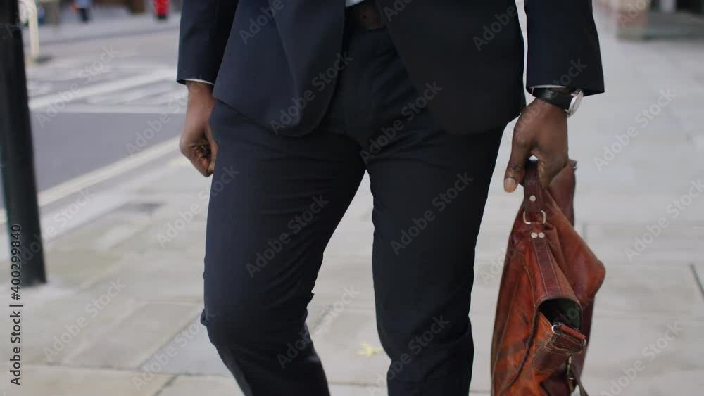 Moving portrait of handsome black professional walking through the city, in slow motion Moving portrait of handsome black professional walking through the city, in slow motion