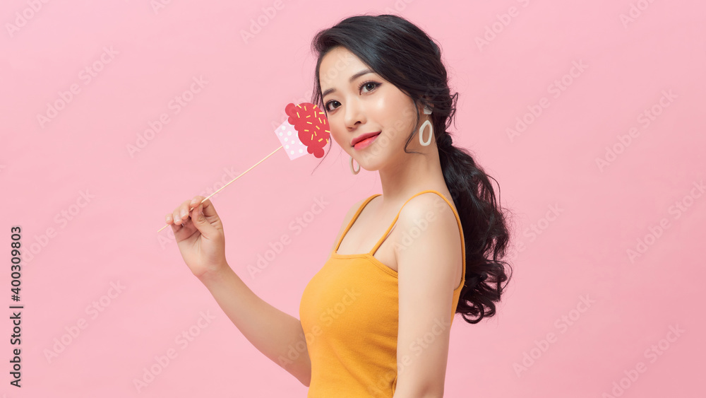 funny asian girl with paper cupcake on stick on pink background. Happy Birthday party funny asian girl with paper cupcake on stick on pink background. Happy Birthday party