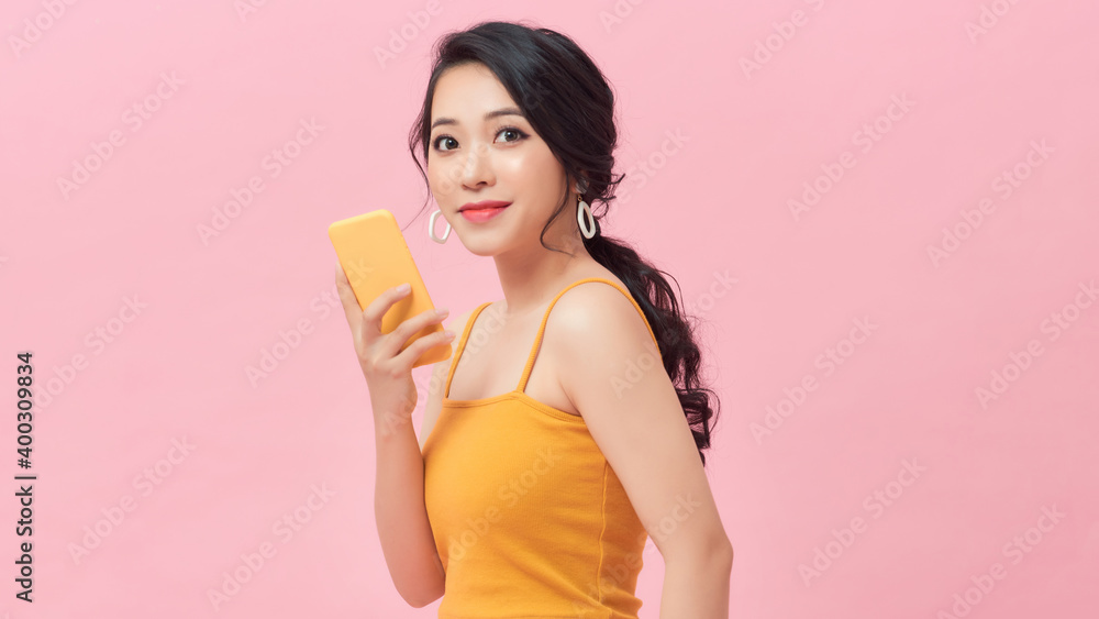 Beauty woman using and reading a smart phone isolated on a pink background Beauty woman using and reading a smart phone isolated on a pink background