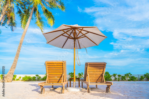 Umbrella and deck chair around outdoor swimming pool in hotel resort