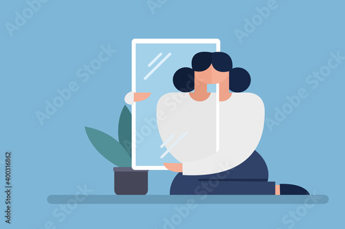 Woman holding a mirror seeing her reflection in it.