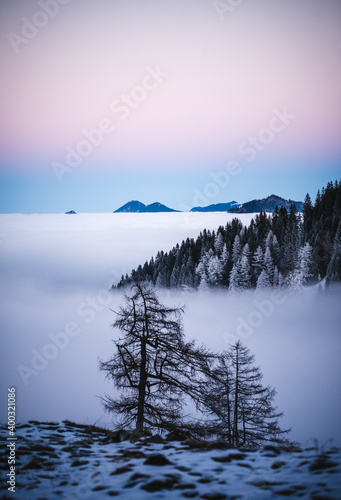 Epic sunset with vivid Colors in the Bavarian mountains in winter for hiking with snow fogs and clouds