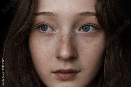 close up portrait of a young woman with freckles © Zaliya