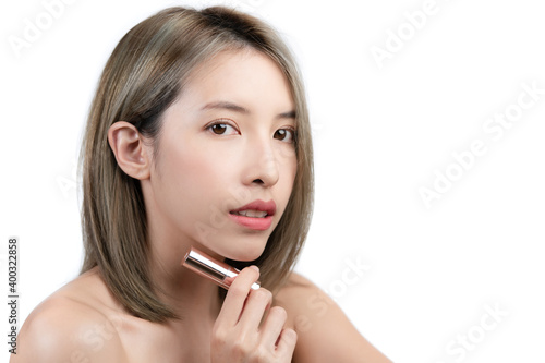 Asian woman holding or presenting lipstick isolated on white background.